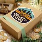 Wooden gift box with 'Coast to Comb' logo on a festive background with cookies and lights.