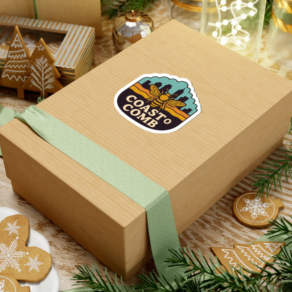 Wooden gift box with a 'Coastal Comb' sticker on a festive background with cookies and greenery.
