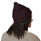 Person wearing a dark purple beanie on a white background