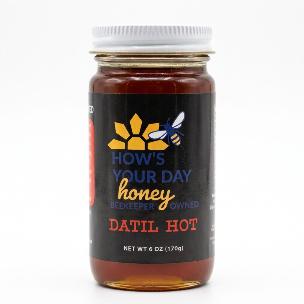 A 6 oz glass jar of 'How's Your Day Honey' in the 'Datil Hot' variety, featuring a black label with yellow and blue branding, a white lid, and amber-colored honey inside, set against a plain white background.