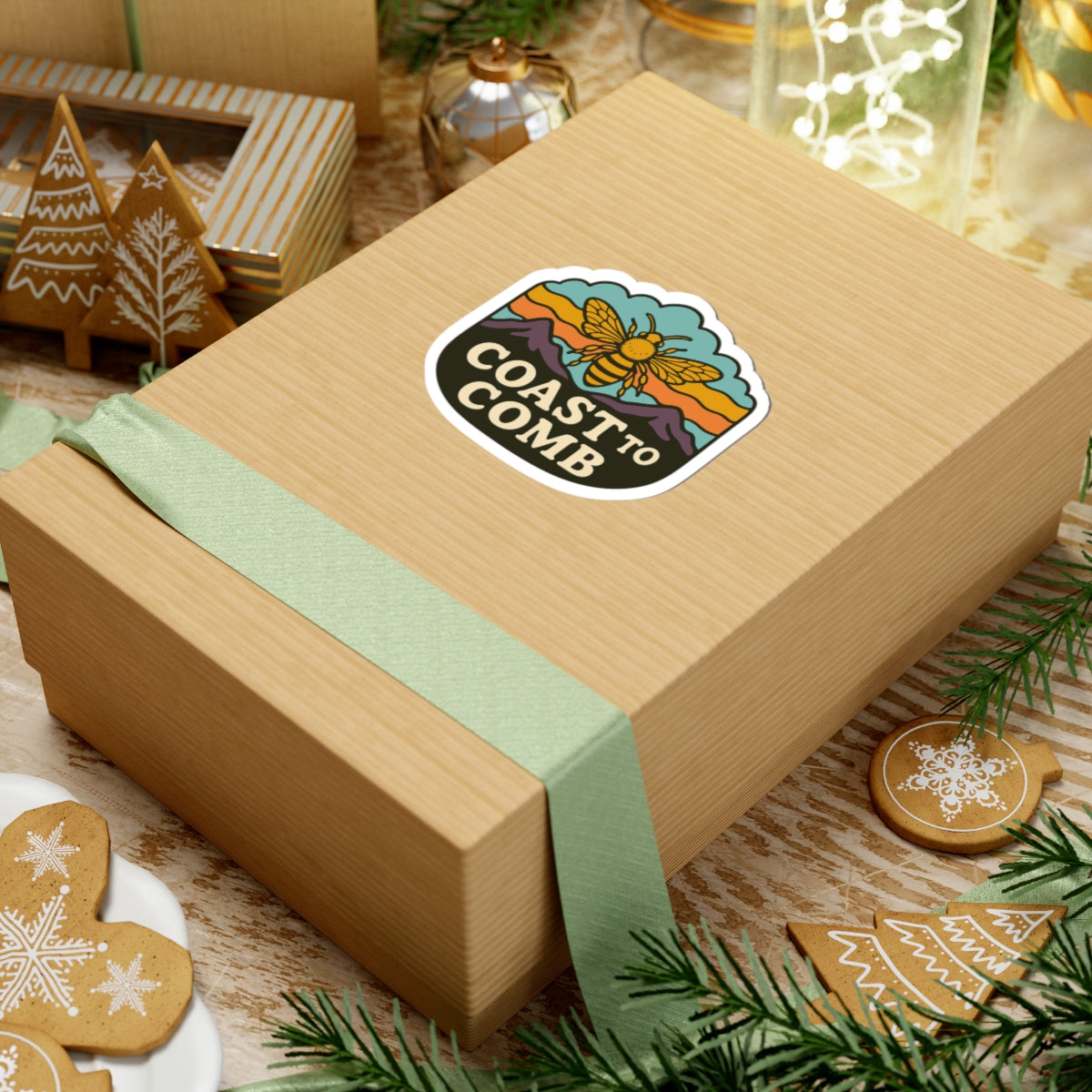 Wooden gift box with a 'Coast to Comb' sticker on a festive background with cookies and greenery.