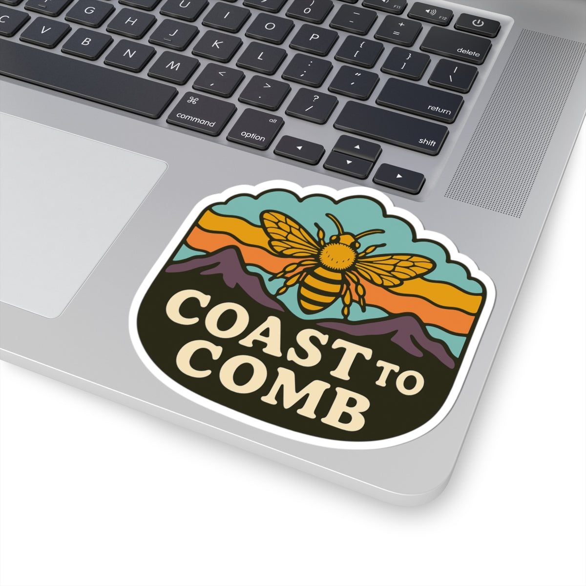Sticker with a bee design and 'Coast to Comb' text on a laptop