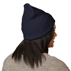 Person wearing a navy blue beanie on a white background