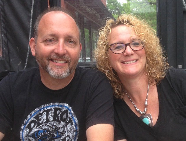 Two people sitting together outdoors with a building in the background